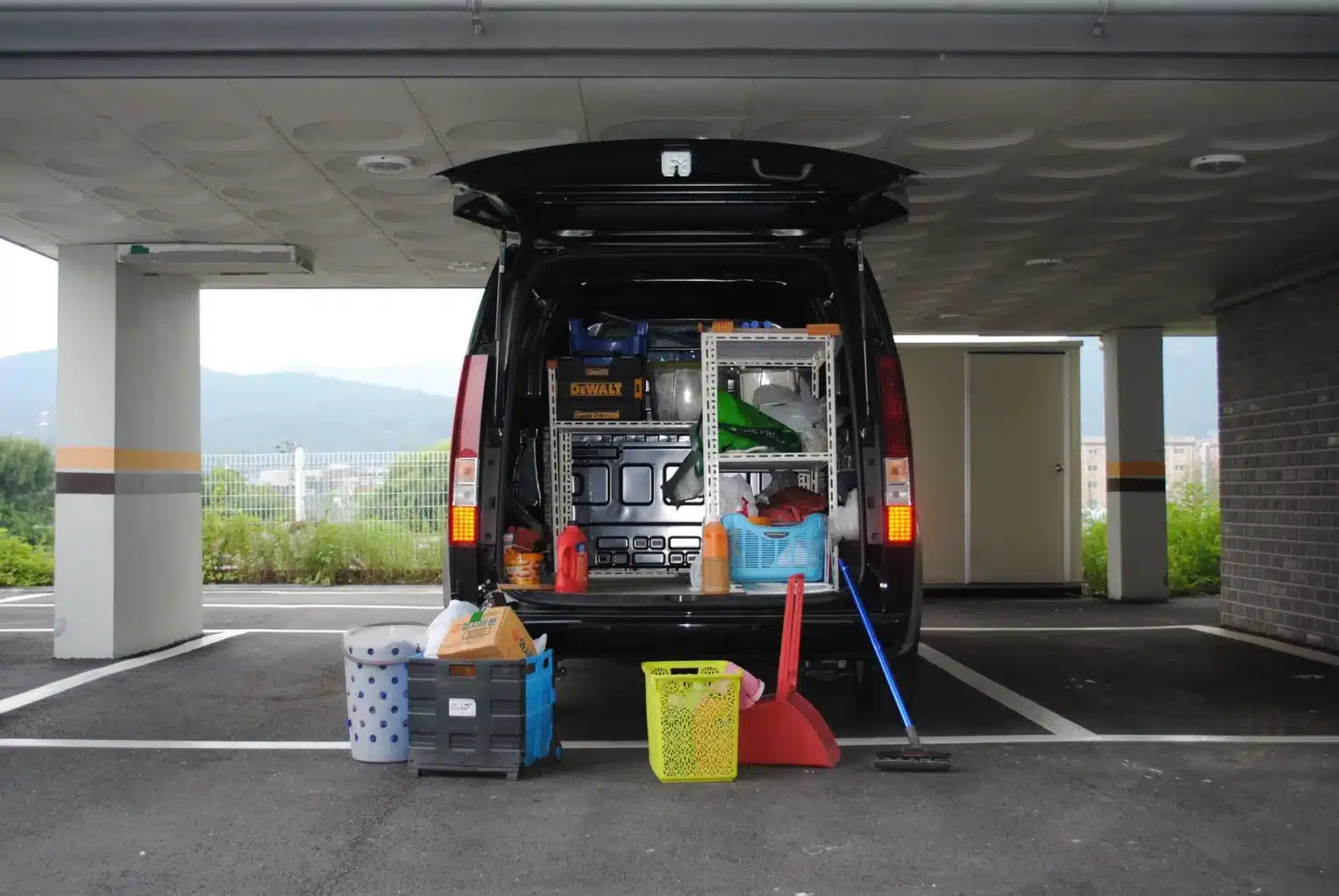 Intérieur d’un garage professionnel avec un utilitaire d’occasion en révision, outils et factures visibles