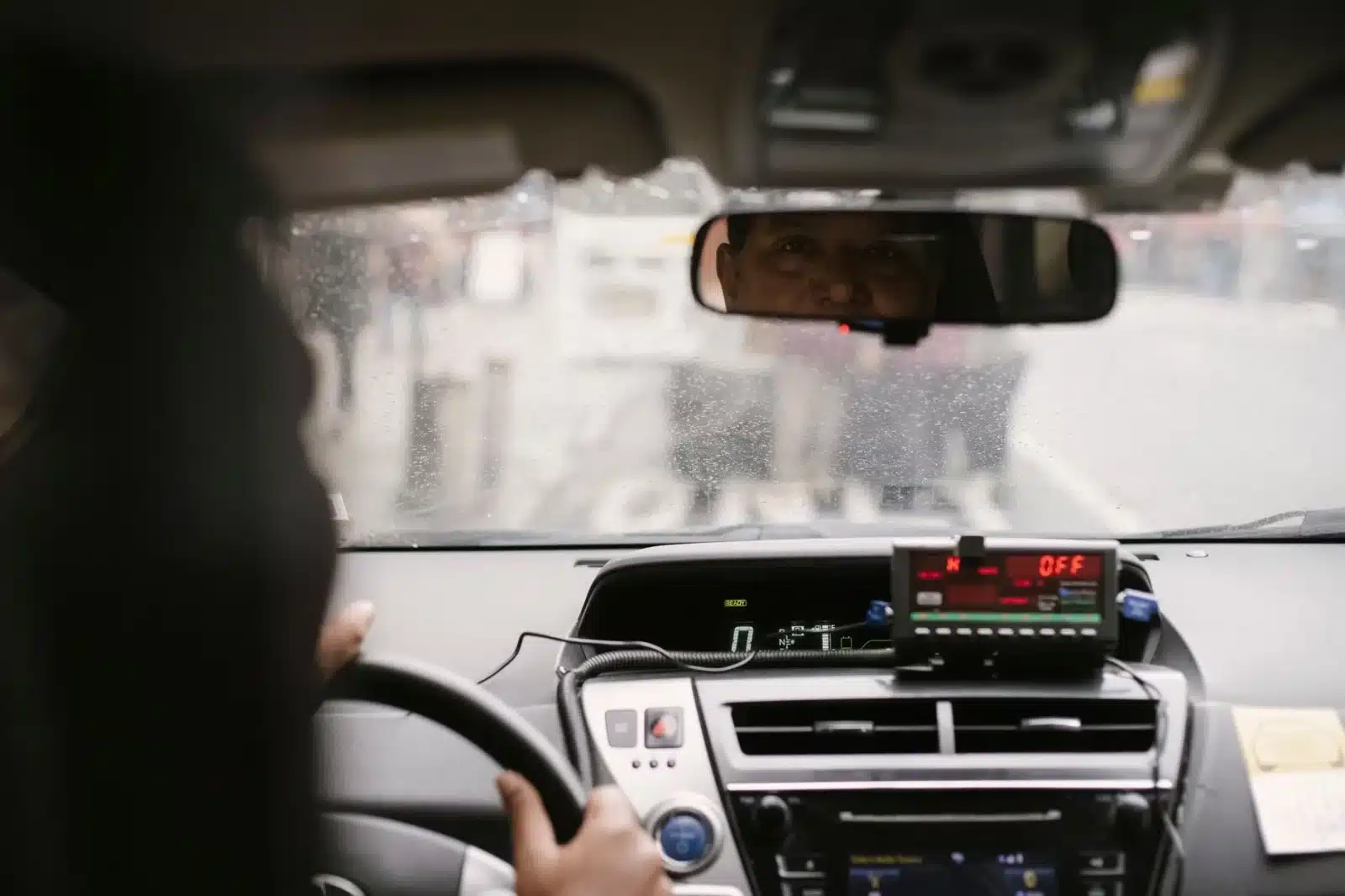 Taxi conventionné CPAM avec vignette visible transportant un patient vers un hôpital