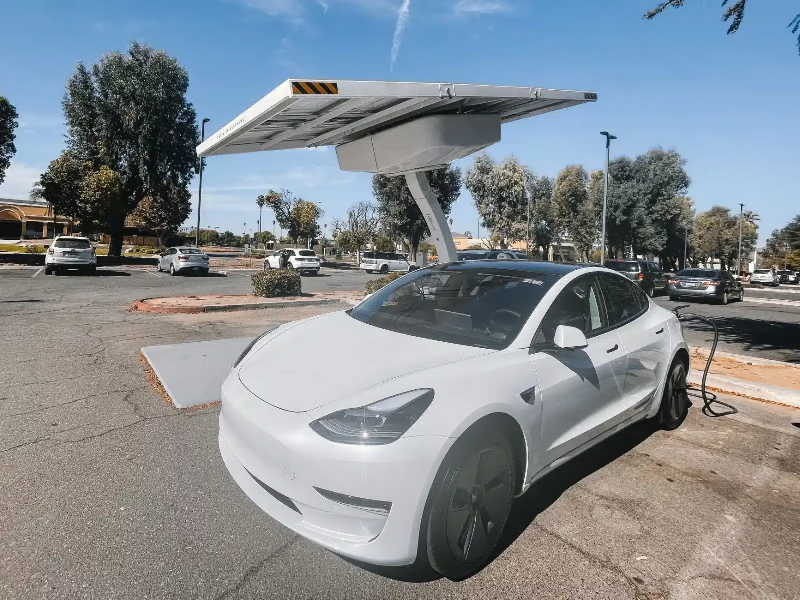 Utilitaire électrique en recharge sur une borne d'entreprise avec panneaux solaires