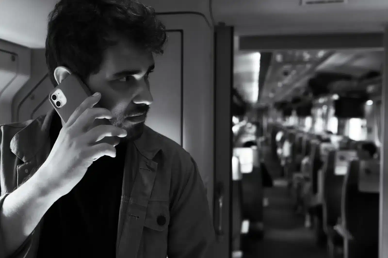 Voyageur consultant son téléphone dans un TGV avec un café à la main