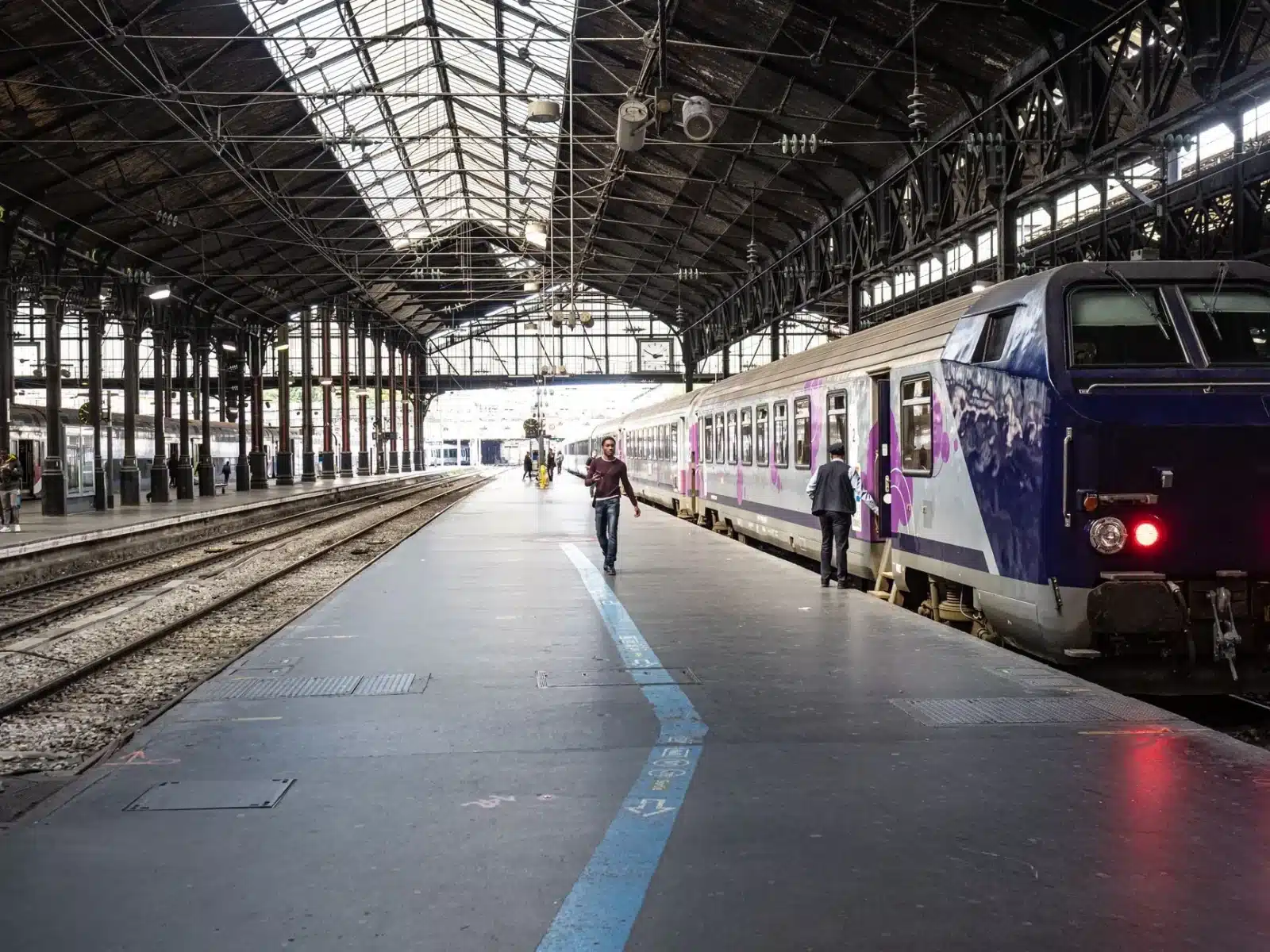 Voyageur consultant un billet de train sur son smartphone en gare